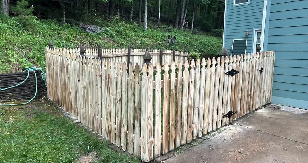 Wood picket enclosure beside a house